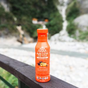 Karviva Detox juice bottle on scenic overlook